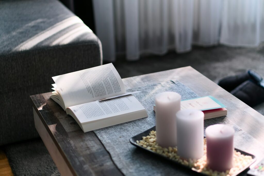 Livro e velas sobre uma mesa de centro, ambiente de leitura reflexiva