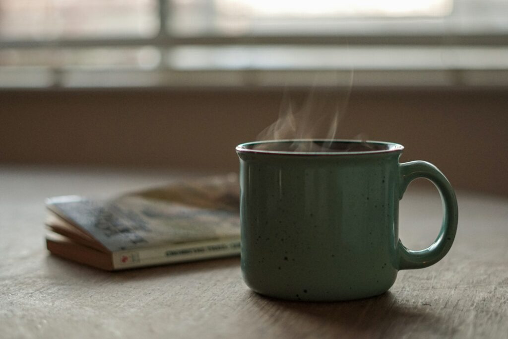 Xícara de café sobre um caderno, representando rotina matinal simples