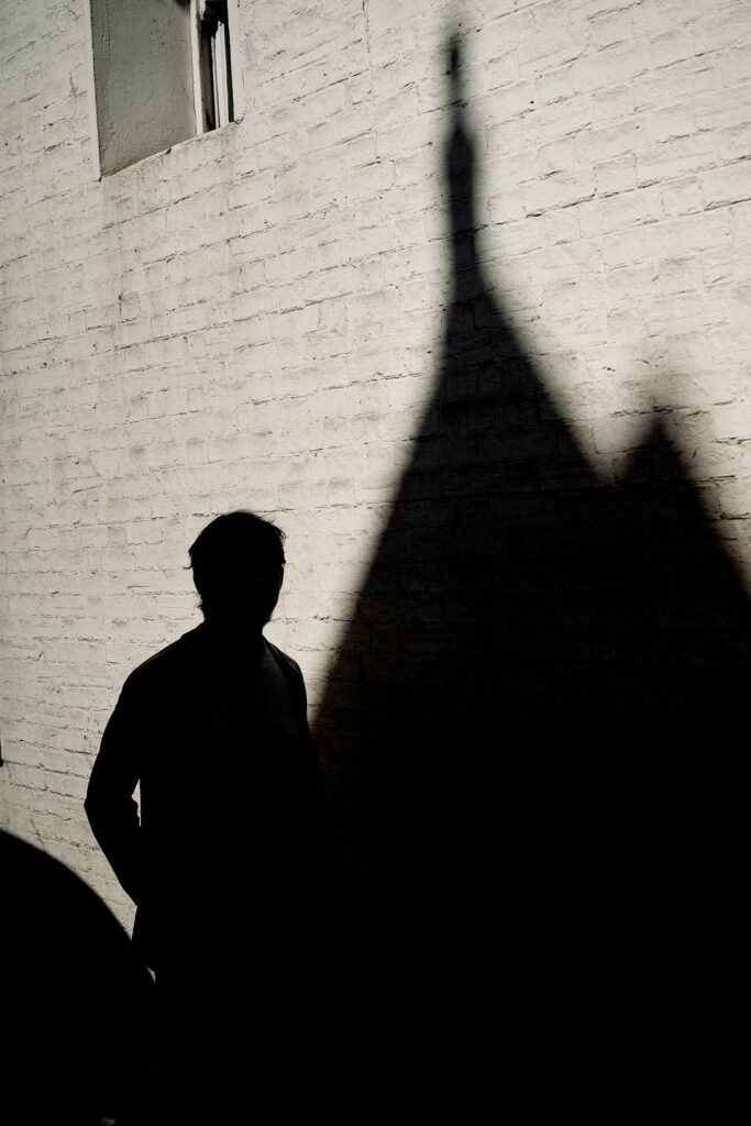 Pessoa caminhando ao entardecer, com a sombra projetada no chão