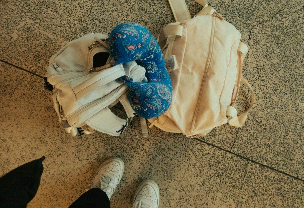 almofada de pescoço de viagem ao lado de bagagem no aeroporto
