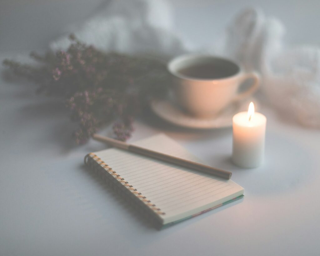Diário aberto com café e planta ao lado, representando o hábito de journaling estoico para praticar amor fati
