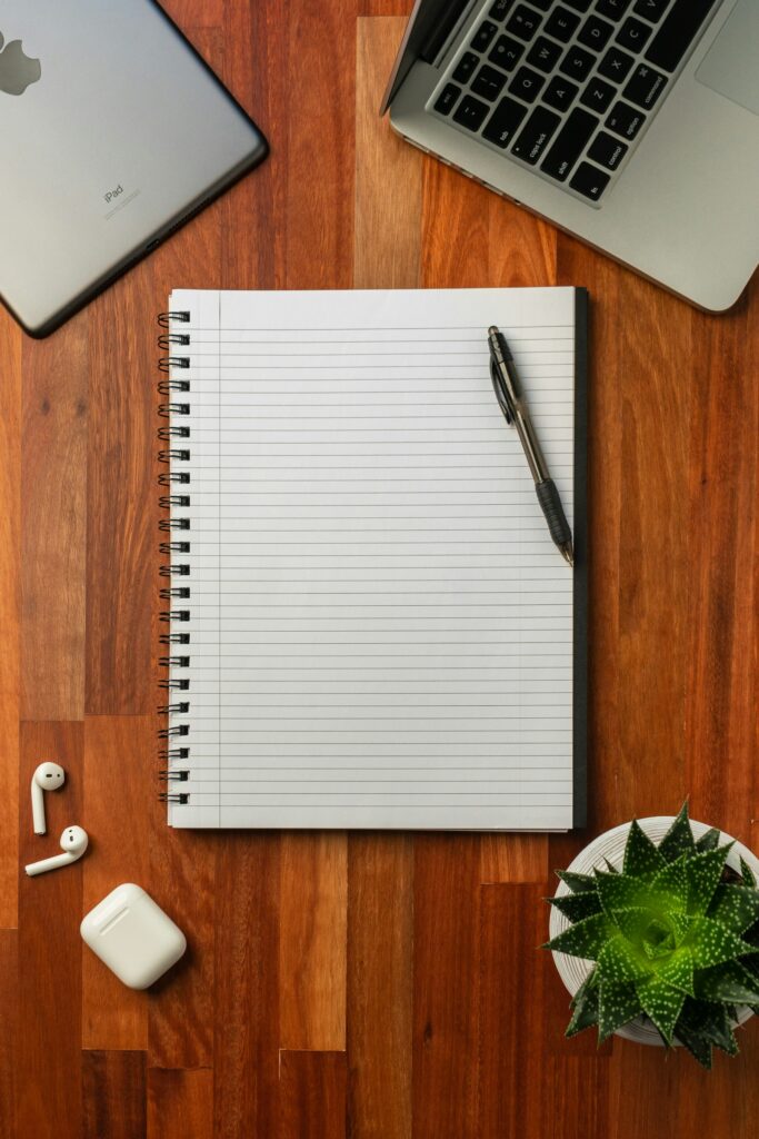 Caderno simples aberto sobre uma mesa de madeira, sem decoração excessiva
