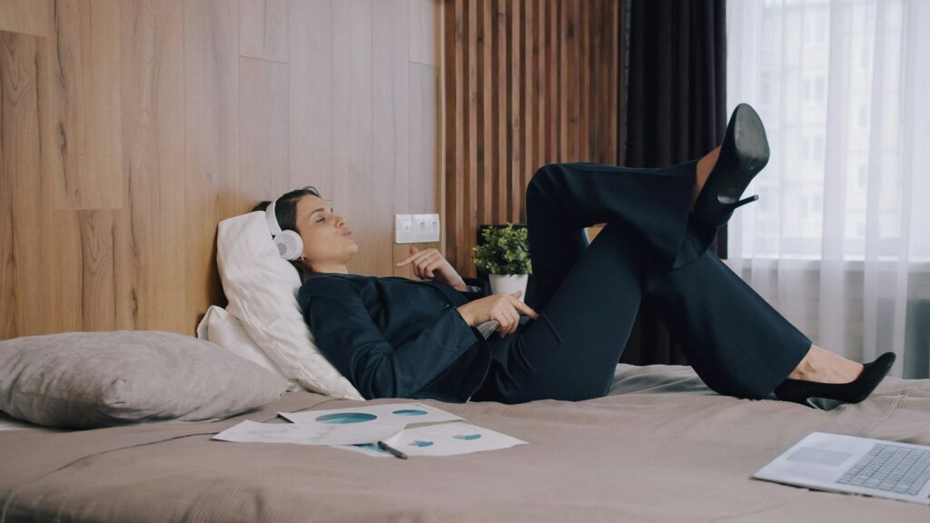 Mulher relaxada usando fone de ouvido para ouvir música antes de dormir