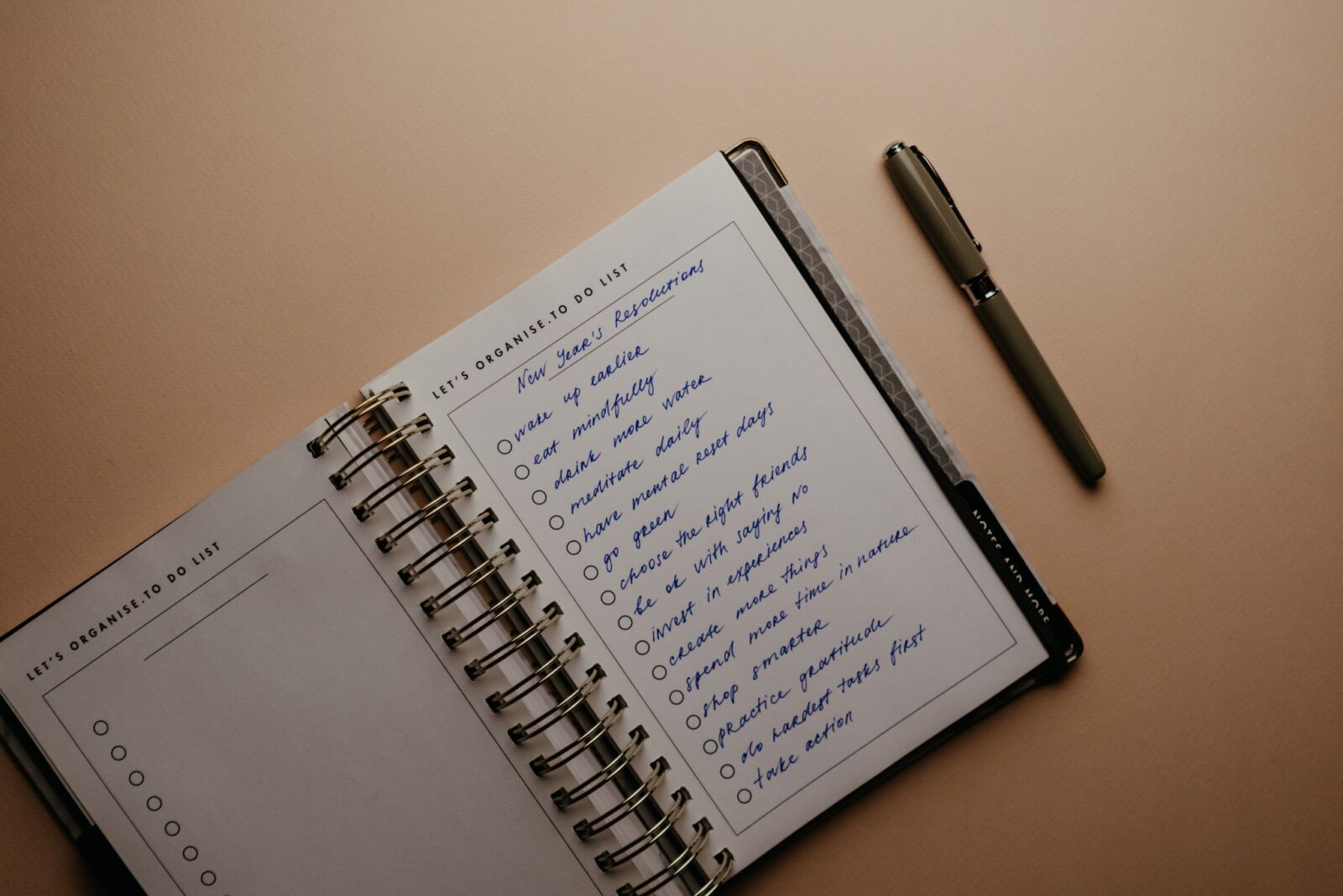 Hábitos atômicos: caderno com lista de hábitos e caneta sobre a mesa