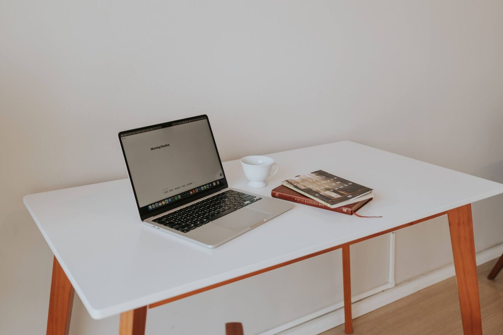 Livro Essencialismo: mesa minimalista com notebook e livros