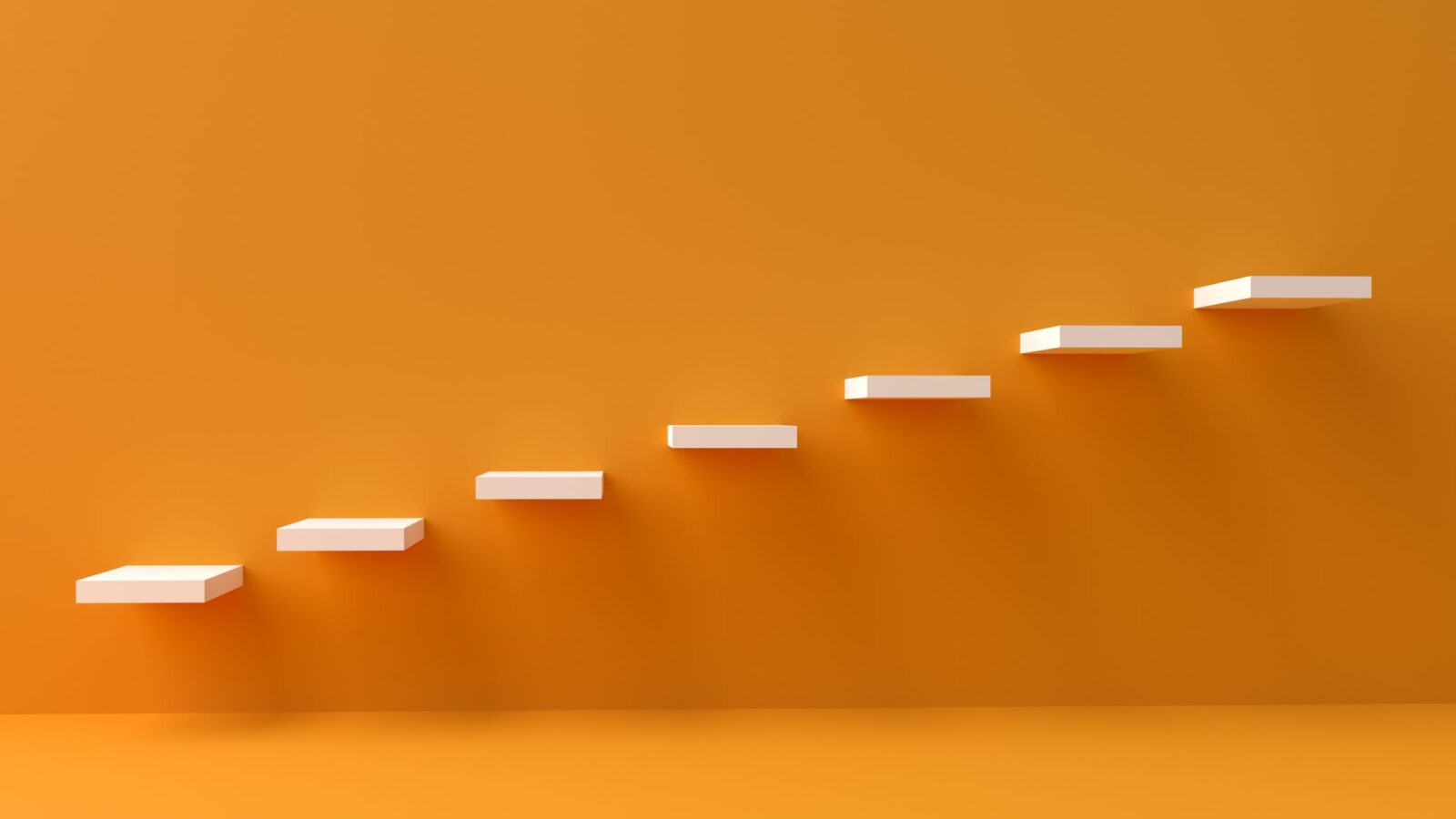 Método kaizen: degraus brancos subindo em uma parede laranja, representando pequenos passos