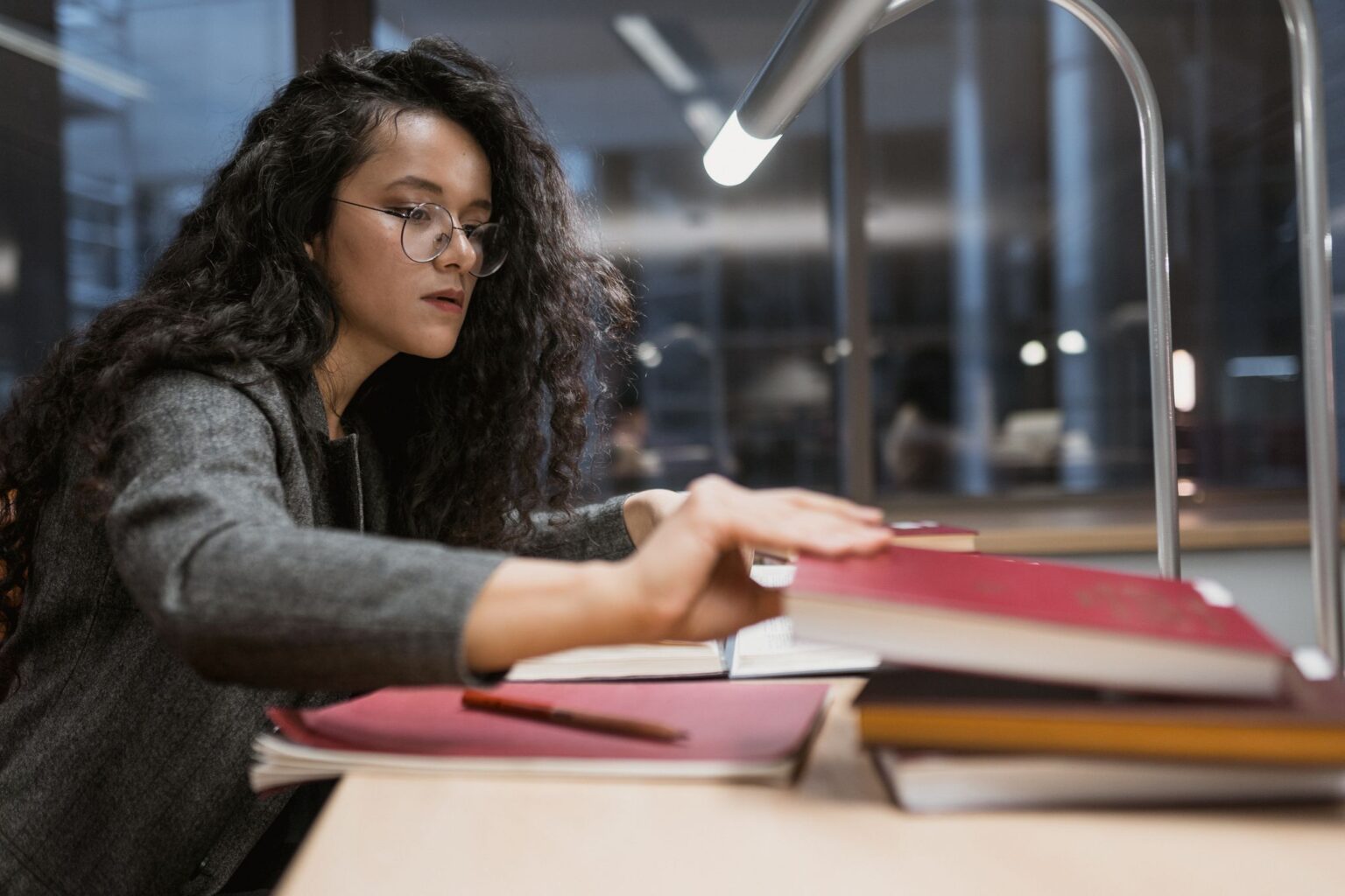 Mindset de crescimento: mulher estudando à mesa sob a luminária