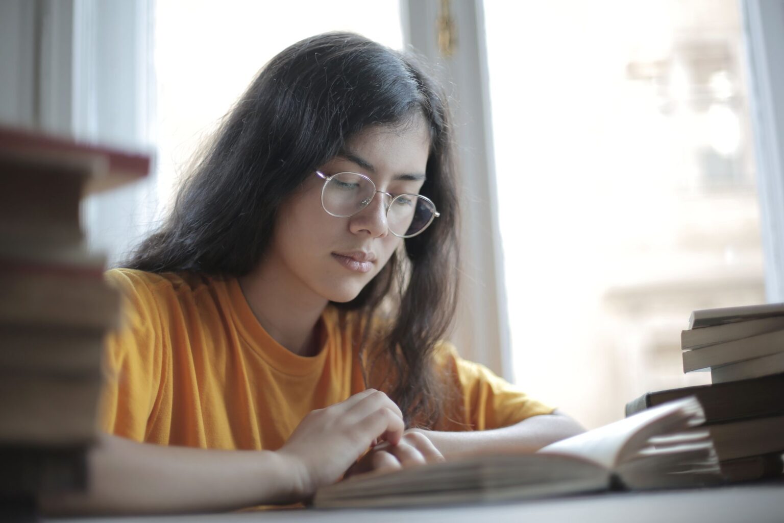 Livro Mindset: mulher lendo e estudando cercada de livros