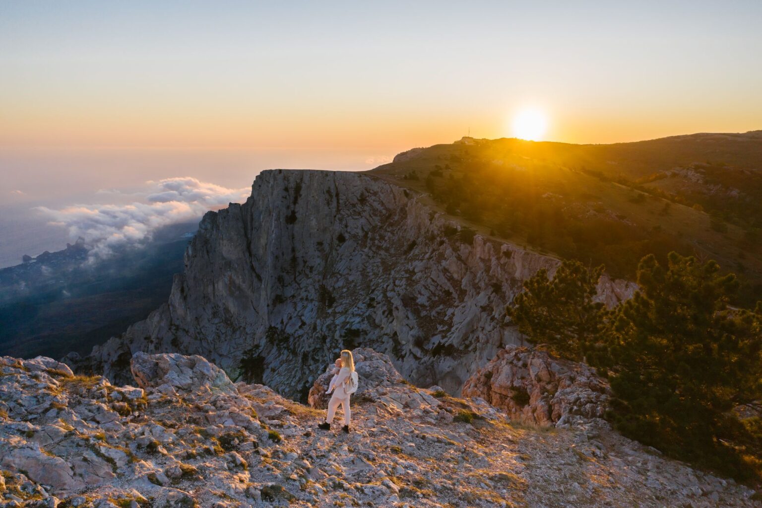 Resiliência emocional: mulher em um penhasco olhando a paisagem