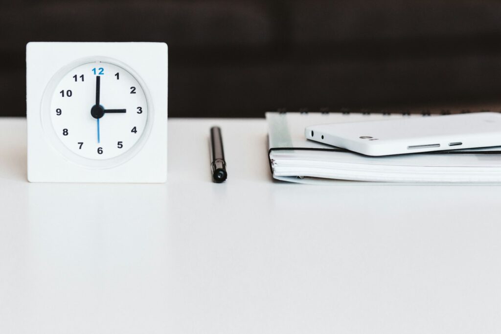Relógio, caneta e planner sobre a mesa, representando a técnica de time blocking