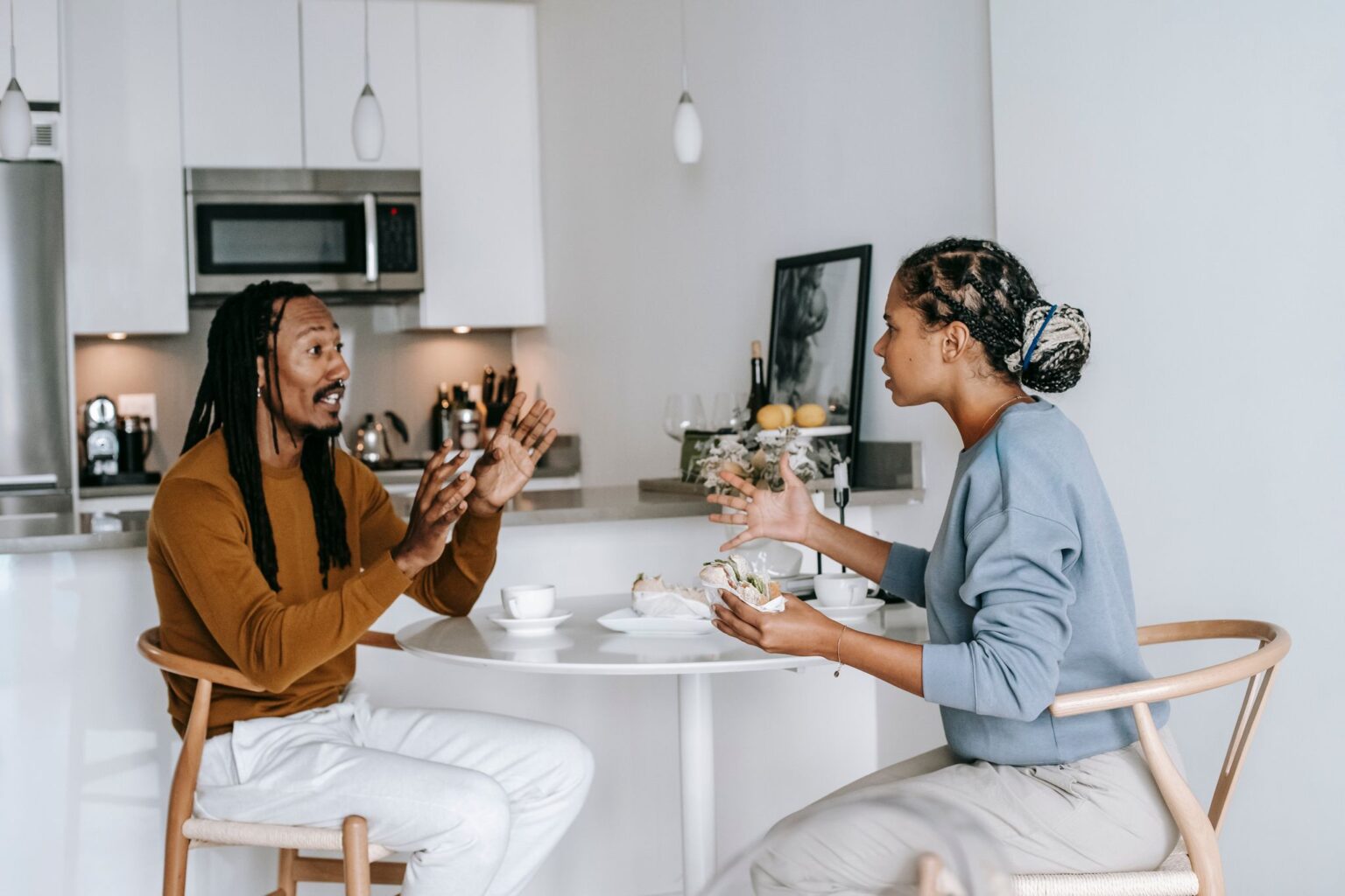 Ciúmes: casal conversando à mesa da cozinha