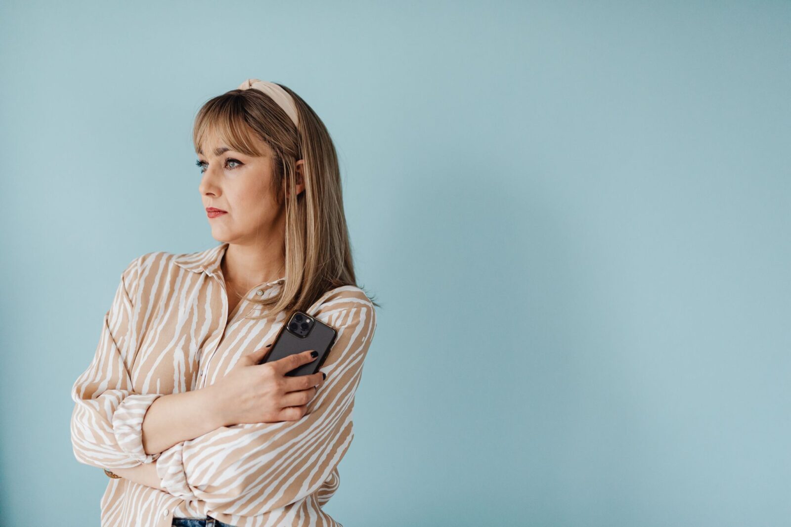 Inveja: mulher pensativa segurando o celular