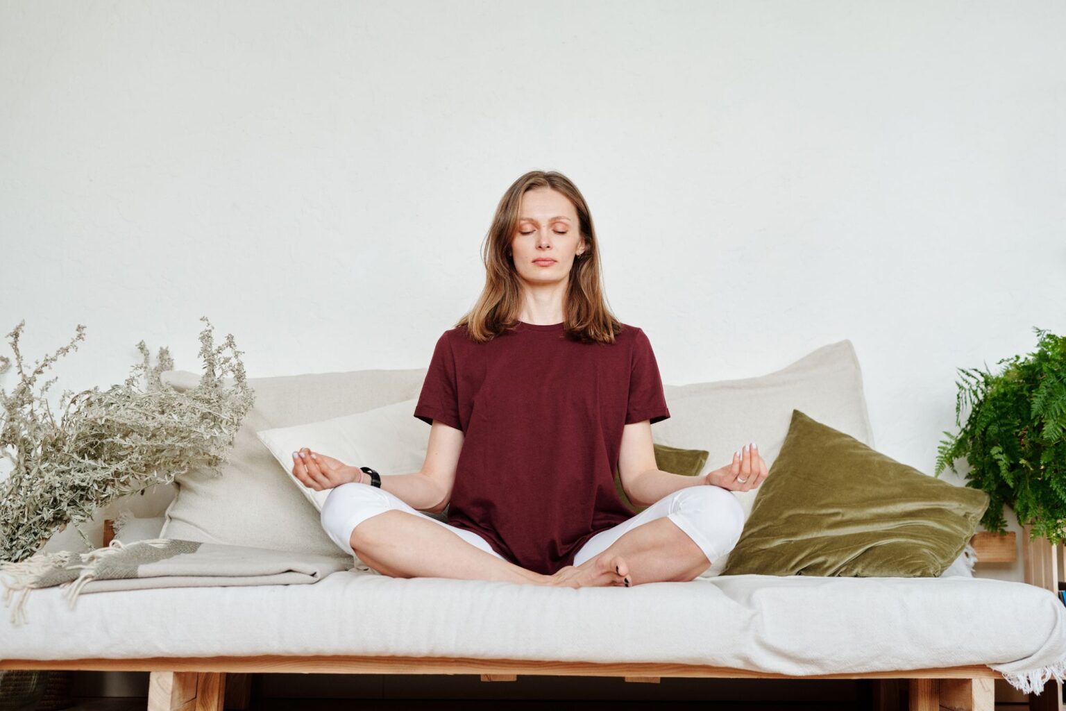 Meditação: mulher meditando no sofá enquanto respira