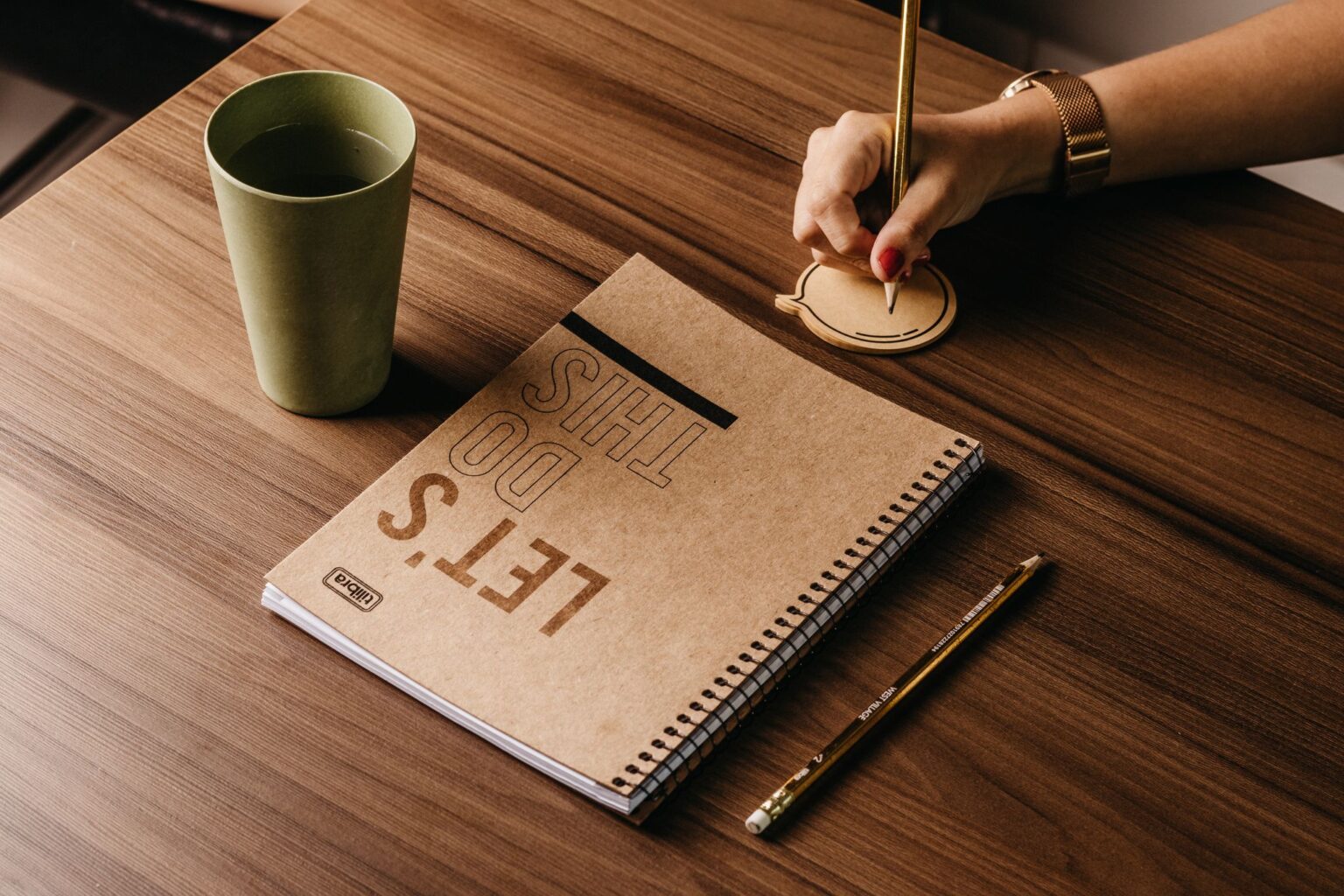 Propósito de vida: mão de mulher escrevendo em um caderno