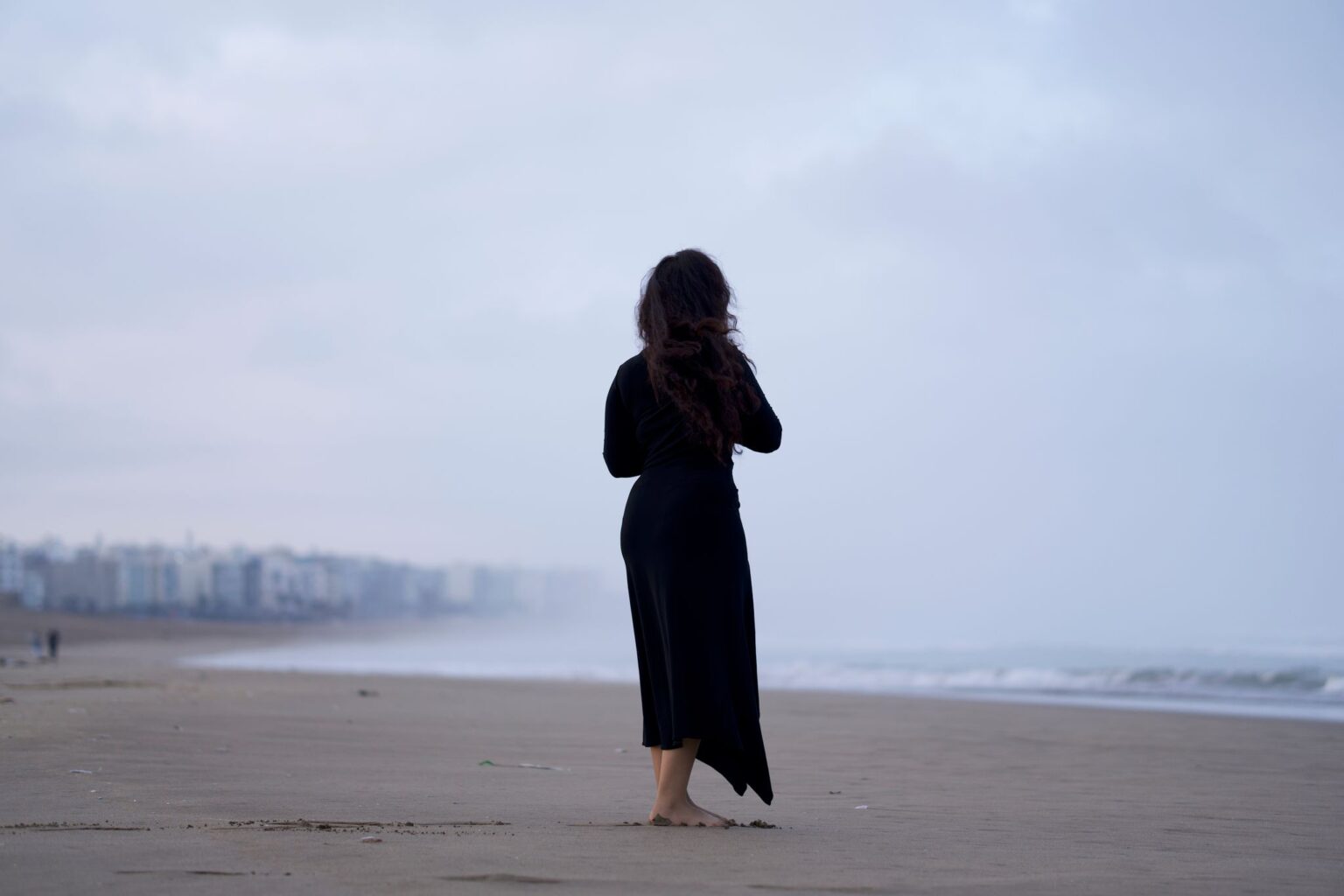 Solidão: mulher sozinha caminhando na praia