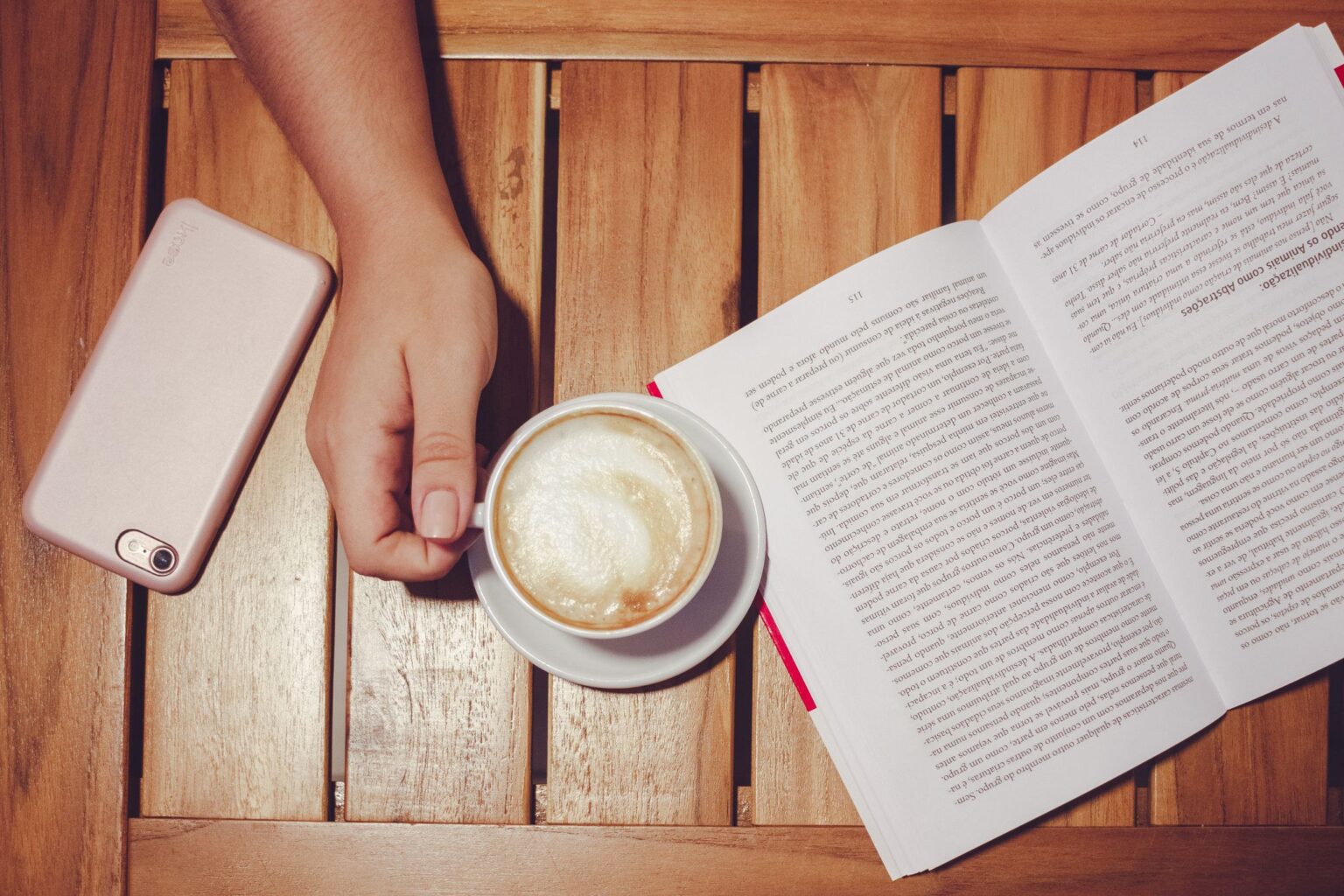 Trabalho Focado: livro aberto ao lado de um café e de um celular