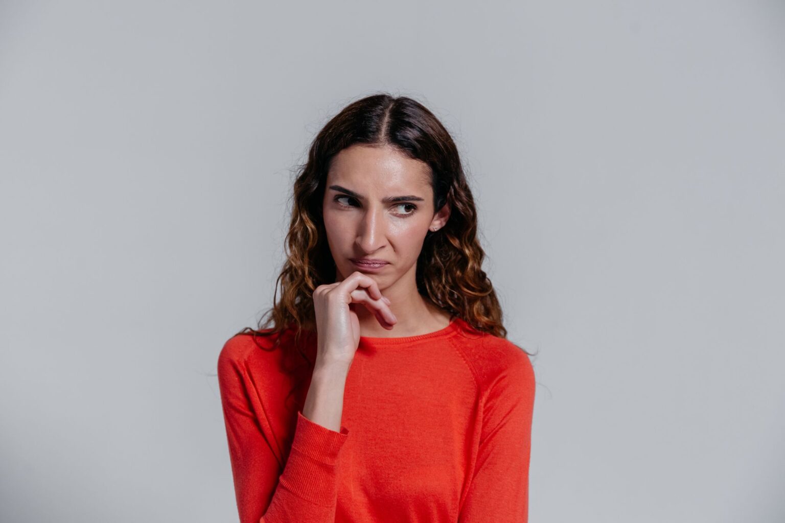 Vergonha: mulher pensativa de suéter vermelho